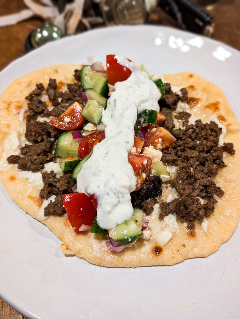 Naan with spinach and feta lamb sausage and toppings